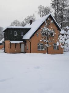 un granero rojo cubierto de nieve en un campo en Apartmány Rudník Bolkov, en Rudník
