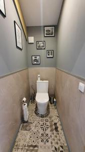 a bathroom with a toilet and a tile floor at Bed'N'Bulles - Wellness privatif in Dinant +7 photos