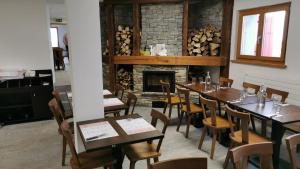 uma sala de jantar com mesas e cadeiras e uma lareira em Cabane Bella-Tola em Saint-Luc