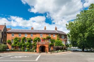 un vecchio edificio in mattoni con cancello di fronte a una strada di The Relais Henley a Henley on Thames