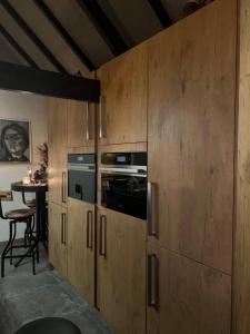 a kitchen with wooden cabinets and a table with a chair at B&B Driel in Driel