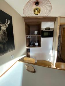une cuisine avec un réfrigérateur blanc et une photo de cerf sur le mur. dans l'établissement Avoriaz le M1212, à Avoriaz