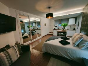 a bedroom with a large bed and a kitchen at Palm View Apartment City center and sea views in Torremolinos