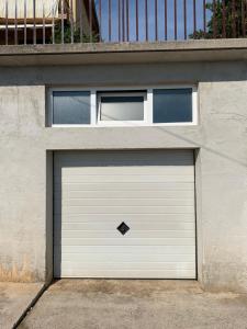 a white garage door on the side of a building at Apartment Ivanka in Senj
