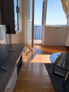 a living room with a table and a large window at Apartment Ivanka in Senj