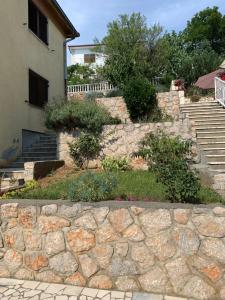 a stone retaining wall in front of a house at Apartment Ivanka in Senj