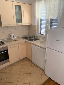 a kitchen with a white refrigerator and a sink at Apartment Ivanka in Senj