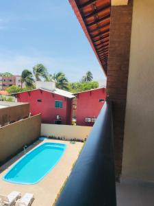 uma vista para uma piscina a partir da varanda de uma casa em Flat Casa da Praia em Porto de Galinhas