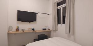 吉安的住宿－花蓮晨風星語民宿Sun Star B&B，卧室设有壁挂式电视和床。
