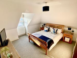 Giường trong phòng chung tại Swanage Holiday Penthouse Apartment, Moments from Beach and Town, On Site Parking, Fast WIFI, Sleeps up to 6, Rated Exceptional