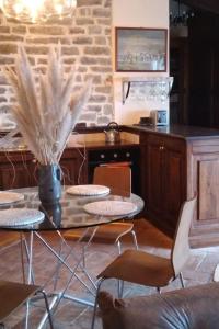 una sala da pranzo con tavolo, sedie e vaso con piume di Villa Pianelli ad Arezzo