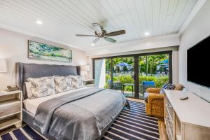 a bedroom with a bed and a flat screen tv at Anna Maria Beach Resort in Holmes Beach +113 photos