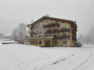 un edificio coperto di neve di fronte di Hotel Valsorda a Moena