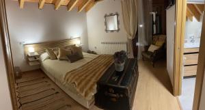 a bedroom with a large bed and a chair at Los Toriles in Los Espejos de la Reina