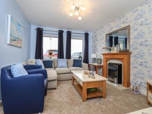 a living room with a blue couch and a fireplace at Solway View in Wigton