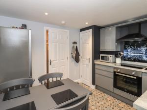 eine Küche mit einem Kühlschrank und einem Tisch mit Stühlen in der Unterkunft Solway View in Wigton