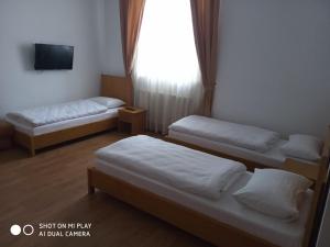 a room with three beds and a tv and a window at Kook Hotel & Rest in Ryasne-Rus'ke