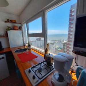 uma cozinha com fogão e vista para o oceano em Hermoso monoambiente con vista al mar en La Perla , Mar del Plata em Mar del Plata