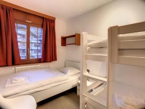 a small room with two bunk beds and a window at Apartment Jacky 7 in Verbier