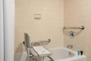 a bathroom with a chair next to a bath tub at Crowne Plaza Englewood by IHG in Englewood