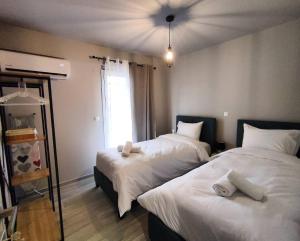 a bedroom with two beds with white sheets at Alexandras cozy apartment Ioannina in Ioannina
