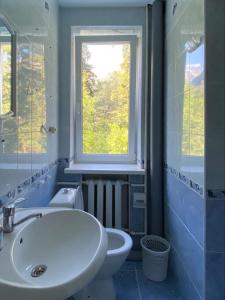 a bathroom with a sink and a toilet and a window at Hotel Moscow in Dombay