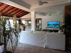 un soggiorno con mobili bianchi e TV a schermo piatto di CASA MARAVILHOSA à BEIRA MAR EM ANGRA DOS REIS ad Angra dos Reis