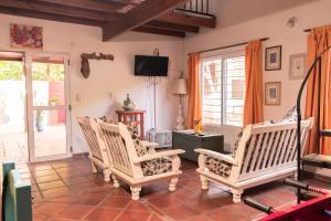 een woonkamer met 3 stoelen en een tv bij Casa Paso de la Patria in Corrientes