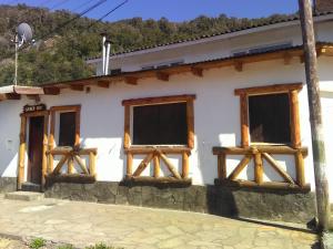 un bâtiment blanc avec des fenêtres en bois dans l'établissement Casa Abedules de los Andes, à San Martín de los Andes