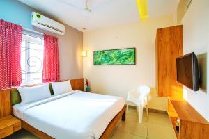 a bedroom with a bed and a television in it at Sarvam Serviced Apartment in Coimbatore