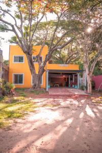 un edificio de naranjos con árboles delante de él en Casa Paso de la Patria en Corrientes