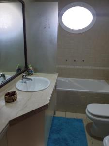 a bathroom with a sink and a toilet and a mirror at Cherrywood House in Dubai