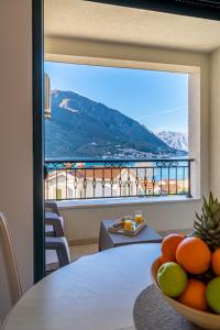 uma taça de fruta numa mesa com uma janela grande em Boka View Luxury Suite - With free Garage Parking em Kotor