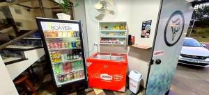 a soda machine in a store next to a car at Hotel Boa Vista in Americana