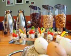 una mesa con varios jarrones llenos de diferentes tipos de comida en Myhotel, en Künzelsau