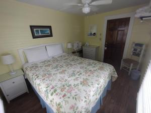 a bedroom with a bed with a floral bedspread at The Angelina Guesthouse - Adult Exclusive in Key West