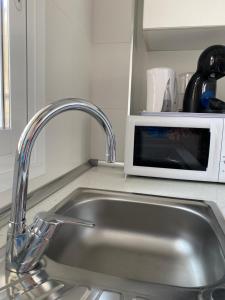 eine Küchenspüle mit einer Mikrowelle auf der Theke in der Unterkunft Estudio Calafin 56 in Finestrat + 33 Fotos