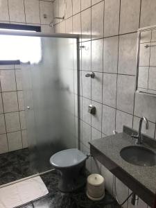 a bathroom with a toilet and a sink at Hotel Boa Vista in Americana