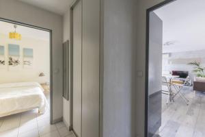 - une chambre avec un lit et une porte coulissante en verre dans l'établissement Superbe Appt Port Marianne, Parking Privé, 4 personnes, à Montpellier