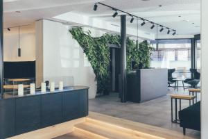 um lobby com plantas na parede e uma mesa em DAS GERLOS - Boutique Hotel em Gerlos