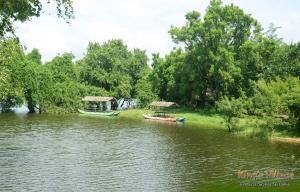 錫吉里亞的住宿－錫吉里亞國王村賓館，两艘船在一条有树的河上
