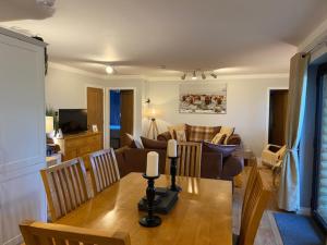 eine Küche und ein Wohnzimmer mit einem Tisch und einem Sofa in der Unterkunft Immaculate 3 bed lodge in Blairgowrie in Blairgowrie