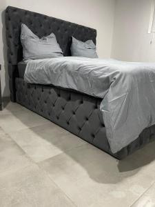 a bed with a black headboard in a room at All In in Oberhausen