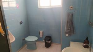 Un baño azul con inodoro y lavabo. en Casa Centro de Peruíbe - R&P, en Peruíbe 12 fotos más