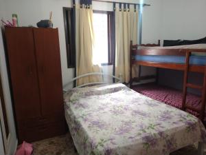 Un dormitorio con una cama y una cómoda y una ventana. en Casa Centro de Peruíbe - R&P, en Peruíbe