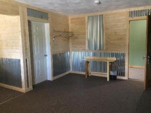 an empty room with a table and a shower at Big Horse Inn and Suites in Lewistown