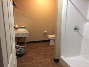 a small bathroom with a toilet and a sink at Big Horse Inn and Suites in Lewistown +1 photo