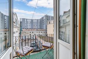 a balcony with chairs and a view of a city at STN Apartments on Rubinsteina Street in Saint Petersburg