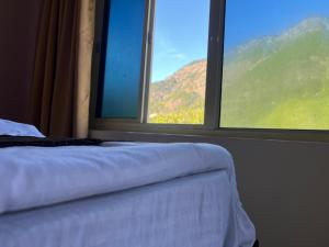 a bedroom with a bed and a large window at River Valley in Chamoli