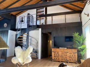 a living room with a spiral staircase and a television at Beautiful Chalet on the piste in Swiss Alps in Alt Sankt Johann